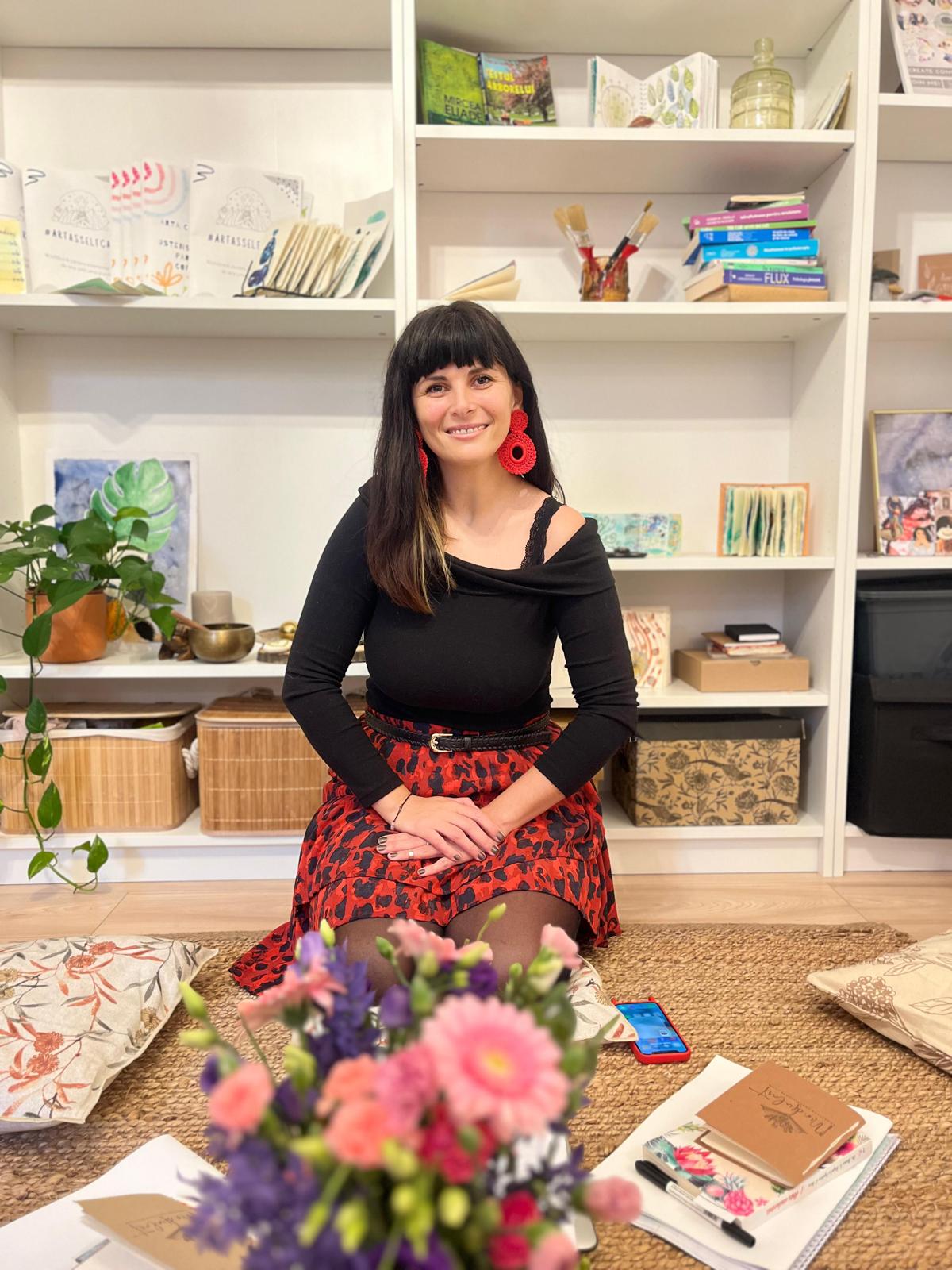 Portret Andrada Costea în atelierul MindfulArt®, în fața rafturilor cu materiale de artă